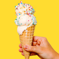 A hand holding an ice cream cone.
