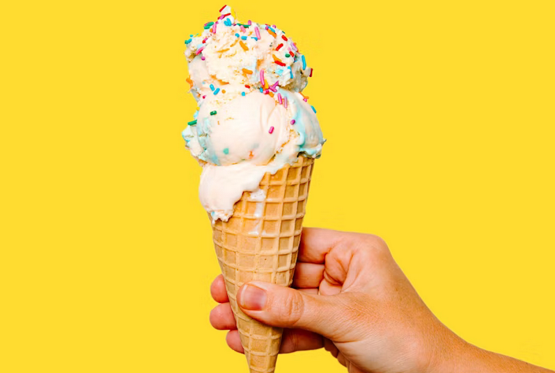 A hand holding an ice cream cone.